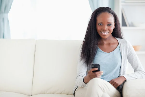 Frau tippt SMS auf dem Sofa — Stockfoto