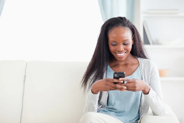 Kvinna i vardagsrummet läsa textmeddelande — Stockfoto