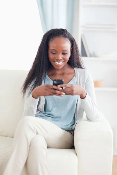 Kvinna i vardagsrummet textmeddelanden — Stockfoto