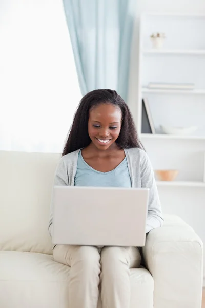 Žena pracuje na svém laptopu na pohovce — Stock fotografie