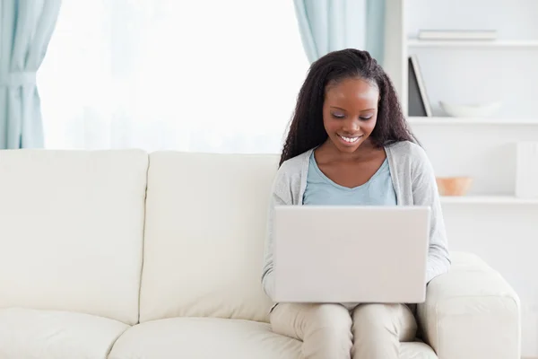 Vrouw in woonkamer met laptop — Stockfoto
