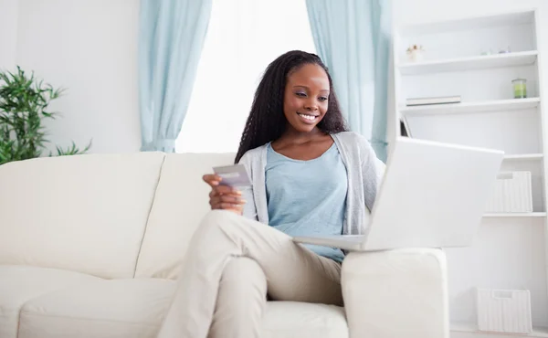 Kvinna shopping på nätet medan du sitter på soffan — Stockfoto