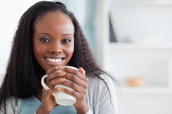 Close up of woman sitting on sofa with a cup — Stock Photo, Image