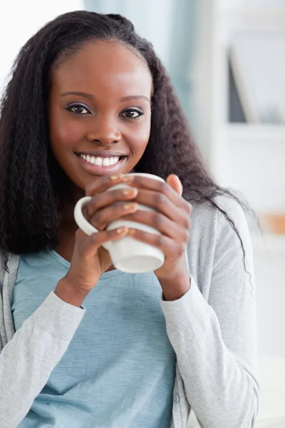 Close up of woman sitting on couch with a cup — Stock Photo, Image