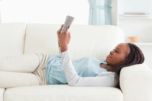 Γυναίκα στον καναπέ, διαβάζοντας ένα μυθιστόρημα — Φωτογραφία Αρχείου