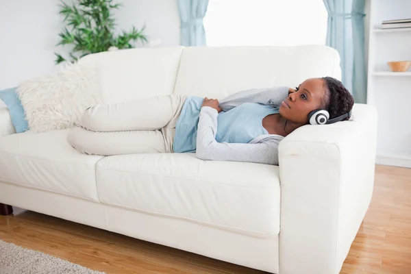 Kvinna på soffa lyssna på musik — Stockfoto