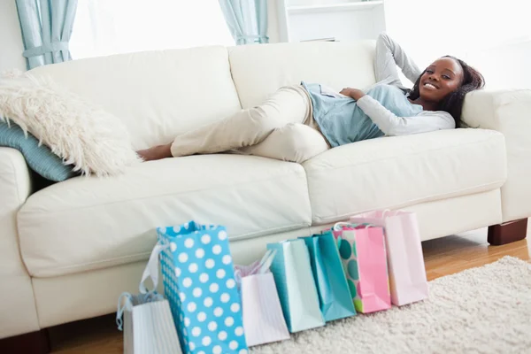 Mujer acostada en el sofá después de ir de compras —  Fotos de Stock