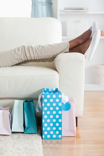 Woman on couch putting her feet up — Stock Photo, Image