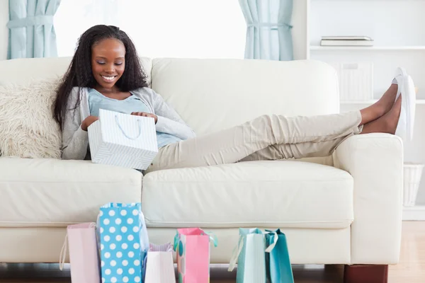 Женщина на диване проверяет покупки — стоковое фото