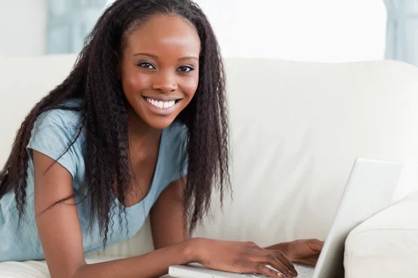 Close up of woman lying on the couch with her laptop — Stock Photo, Image