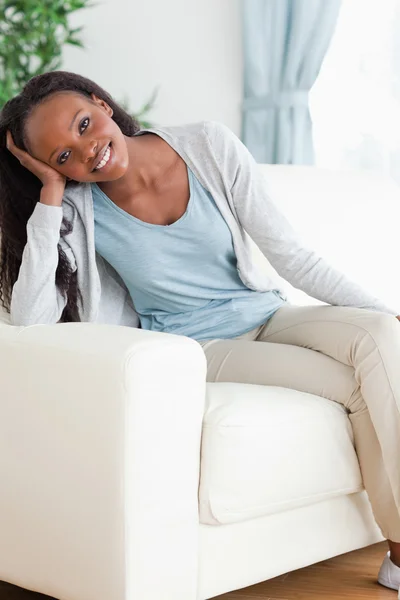 Žena se těší, sedí na pohovce — Stock fotografie