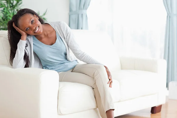 Kobieta cieszy się siedzi na kanapie — Zdjęcie stockowe