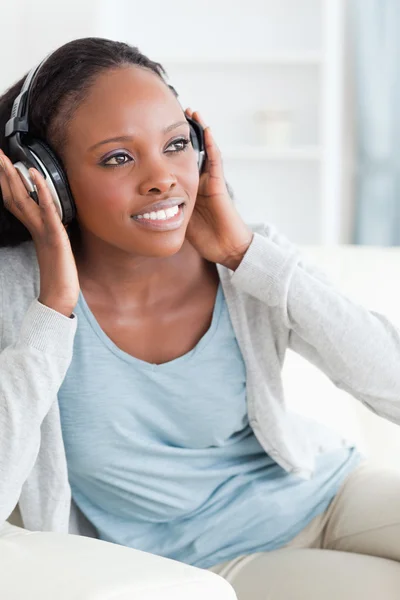 Close up of woman enjoying music on the couch — Stock Photo, Image