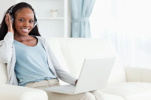 Vrouw met behulp van haar laptop terwijl u luistert naar muziek — Stockfoto
