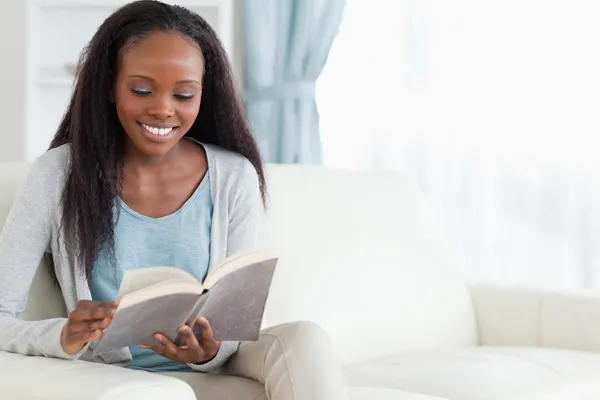 Vrouw op sofa met boek — Stockfoto