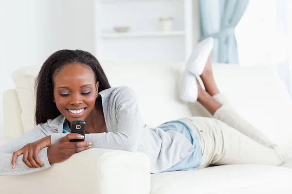 Frau textet auf Couch — Stockfoto
