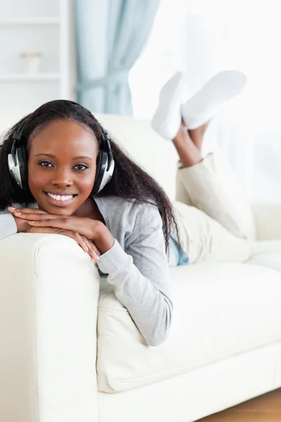 Женщина наслаждается музыкой на диване — стоковое фото