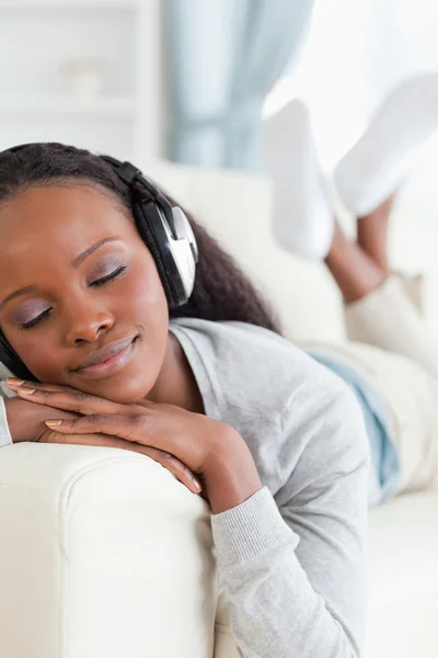Primer plano de la mujer disfrutando de la música en el sofá — Foto de Stock