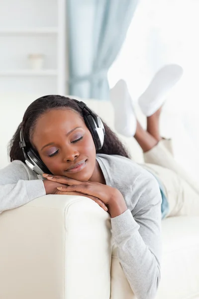 Donna godendo la musica sul suo divano — Foto Stock