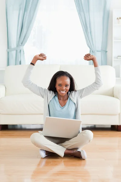 Mulher se alongando enquanto sentado no chão com laptop — Fotografia de Stock