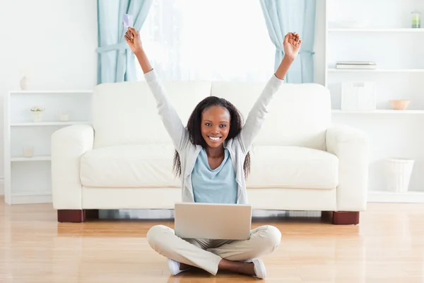 Woman stretching while sitting on the floor working on laptop — Stock Photo, Image