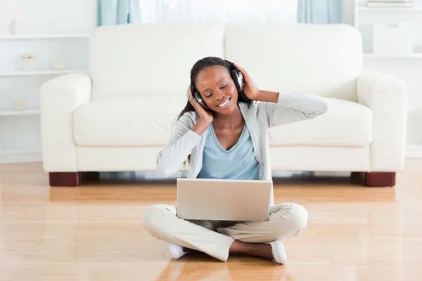 Mujer sentada en el suelo disfrutando de la música — Foto de Stock