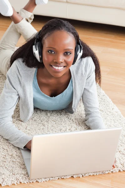 Close up van vrouw met laptop beluisteren op de vloer liggen — Stockfoto