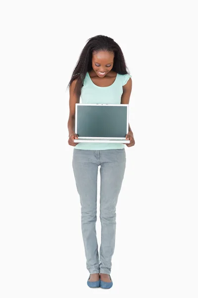Mulher mostrando sua tela de laptop no fundo branco — Fotografia de Stock