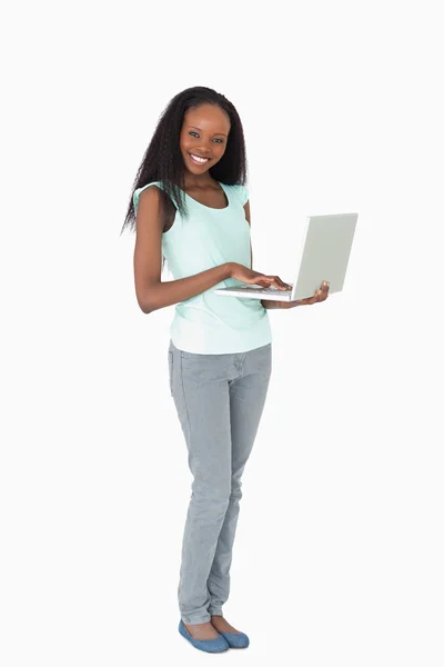 Mulher digitando em seu laptop no fundo branco — Fotografia de Stock