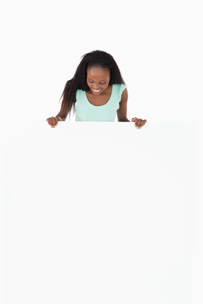 Kvinna som tittar på platshållare i händerna på vit bakgrund — Stockfoto