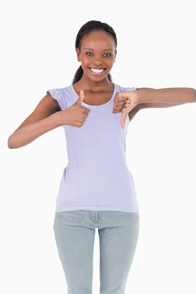 Close up of woman giving one thumb up and one down on white back — Stock Photo, Image
