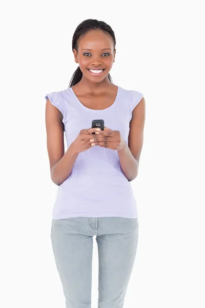 Primo piano della donna che tiene il cellulare su sfondo bianco — Foto Stock