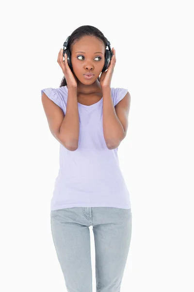 Nahaufnahme einer Frau, die Musik auf weißem Hintergrund hört — Stockfoto