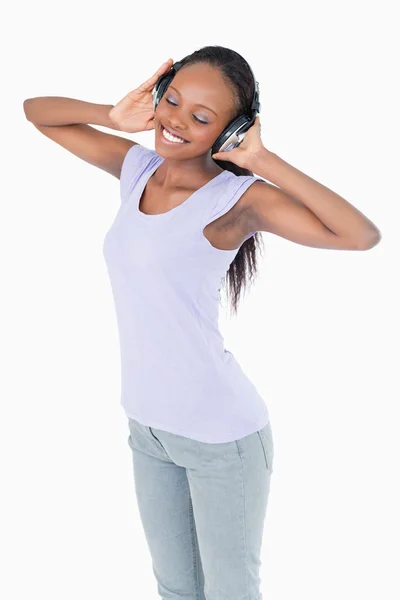 Nahaufnahme einer Frau, die Musik mit Kopfhörern auf weißem Ba hört — Stockfoto