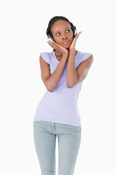 Close up de mulher desfrutando de música com fones de ouvido no backgr branco — Fotografia de Stock