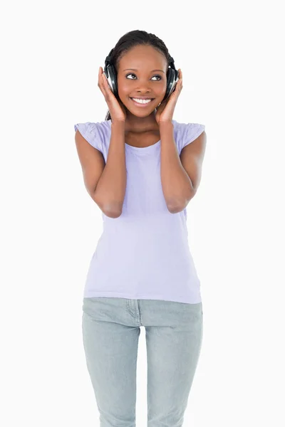Close up de mulher feliz ouvindo música no fundo branco — Fotografia de Stock