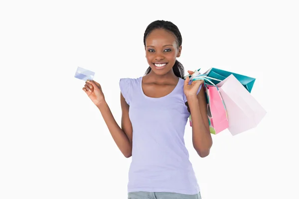 Mulher feliz com suas compras e cartão de crédito no backgroun branco — Fotografia de Stock