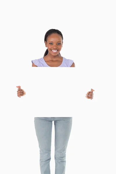 Mulher feliz apresentando placeholder no fundo branco — Fotografia de Stock
