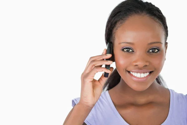 Крупный план молодой женщины по телефону на белом фоне — стоковое фото