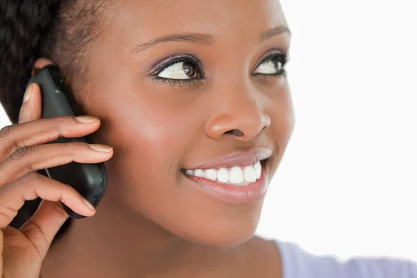 Close up de mulher ouvindo chamador no fundo branco — Fotografia de Stock