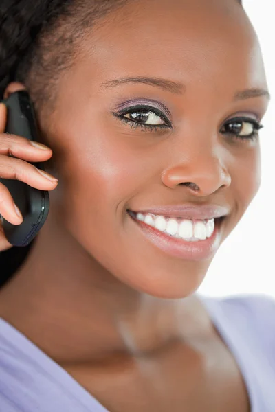 Close up de mulher falando no telefone celular contra um ba branco — Fotografia de Stock