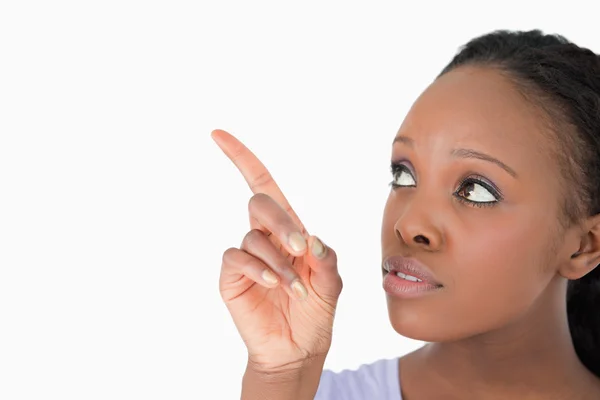 Close up of woman pointing at something next to her on a white b — Stock Photo, Image