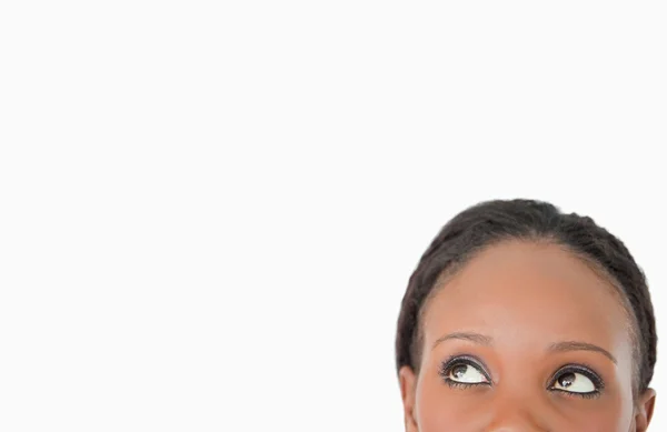 Nahaufnahme einer Frau, die diagonal auf weißem Hintergrund nach oben blickt — Stockfoto
