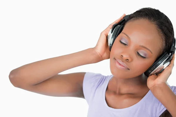 Nahaufnahme einer Frau mit Kopfhörern vor weißem Hintergrund — Stockfoto