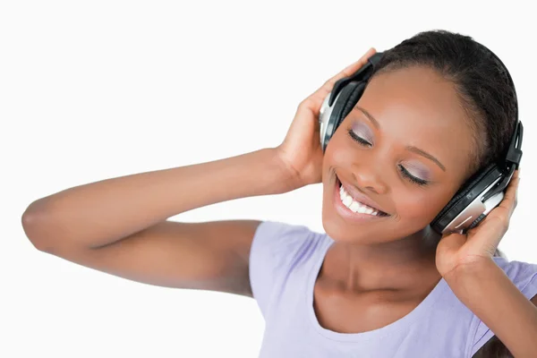 Close up van vrouw luisteren naar muziek tegen een witte achtergrond — Stockfoto
