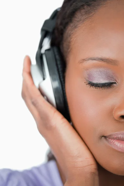 Close up of woman enjoying music against a white background — Stock Photo, Image