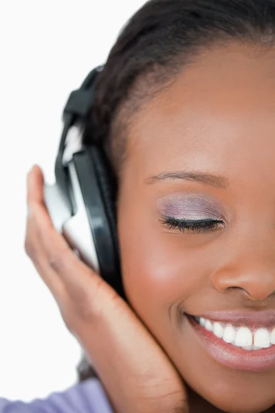 Close up of young woman listening to music on white background — Stock Photo, Image