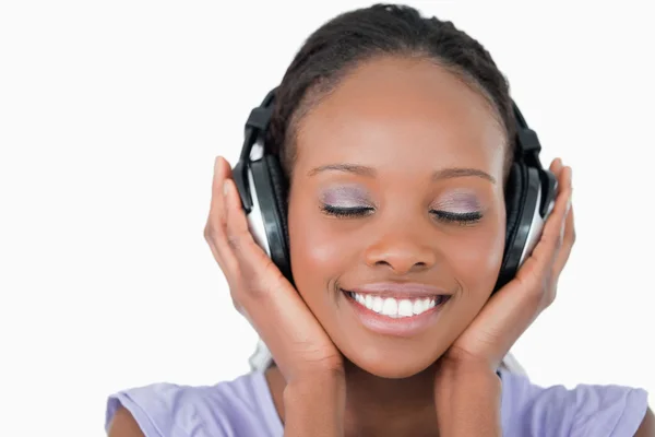 Close up van jonge vrouw luisteren naar muziek met koptelefoon op wh — Stockfoto