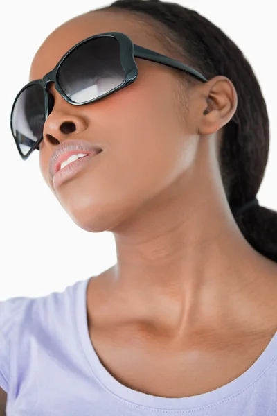 Närbild på kvinna som bär hennes solglasögon på vit bakgrund — Stockfoto