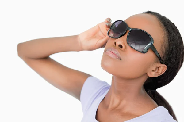 Close up de mulher movendo seus óculos de sol contra um backgrou branco — Fotografia de Stock